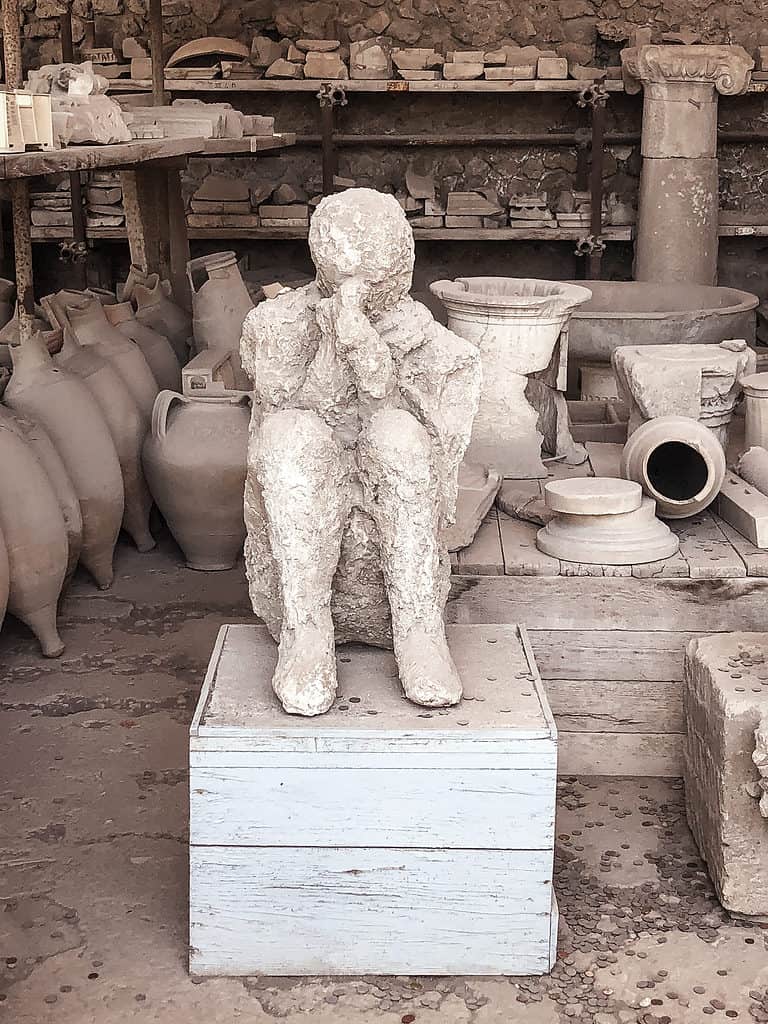 Best things to do in Pompeii, Ancient stone statue at Pompeii ruins Italy reminding travelers to use common sense when visiting popular tourist sites.