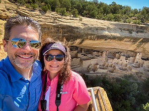 Chris and Jo smiling at the Cliff Palace overlook during their Mesa Verde national park road trip in Colorado.