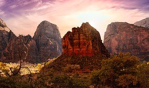 Sunlit rock formations rising above a dramatic landscape, highlighting some of the best day hikes in the world.