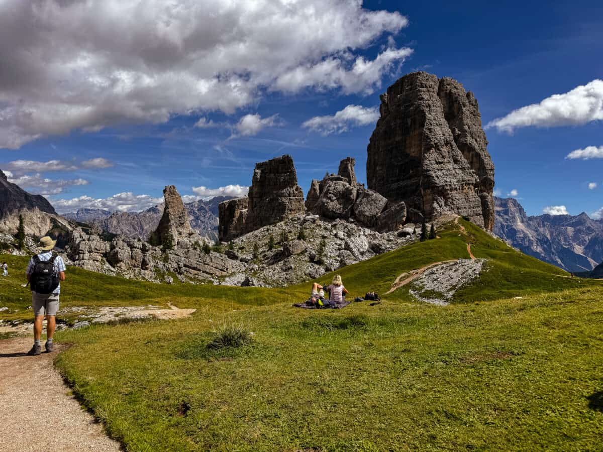20260826 cinquetorri 2603 Hikers rest below the Cinque Torri rock towers near Cortina d'Ampezzo in the Dolomites of Northern Italy.