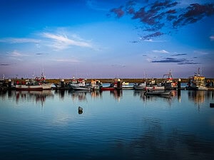 Discover the sunset overlooking boats from Santa Luzia in Portugal when looking for things to do in the Algarve.