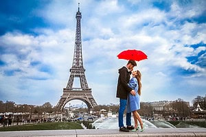 Romantic things to do in Europe with couple standing in front of the eiffel tower.