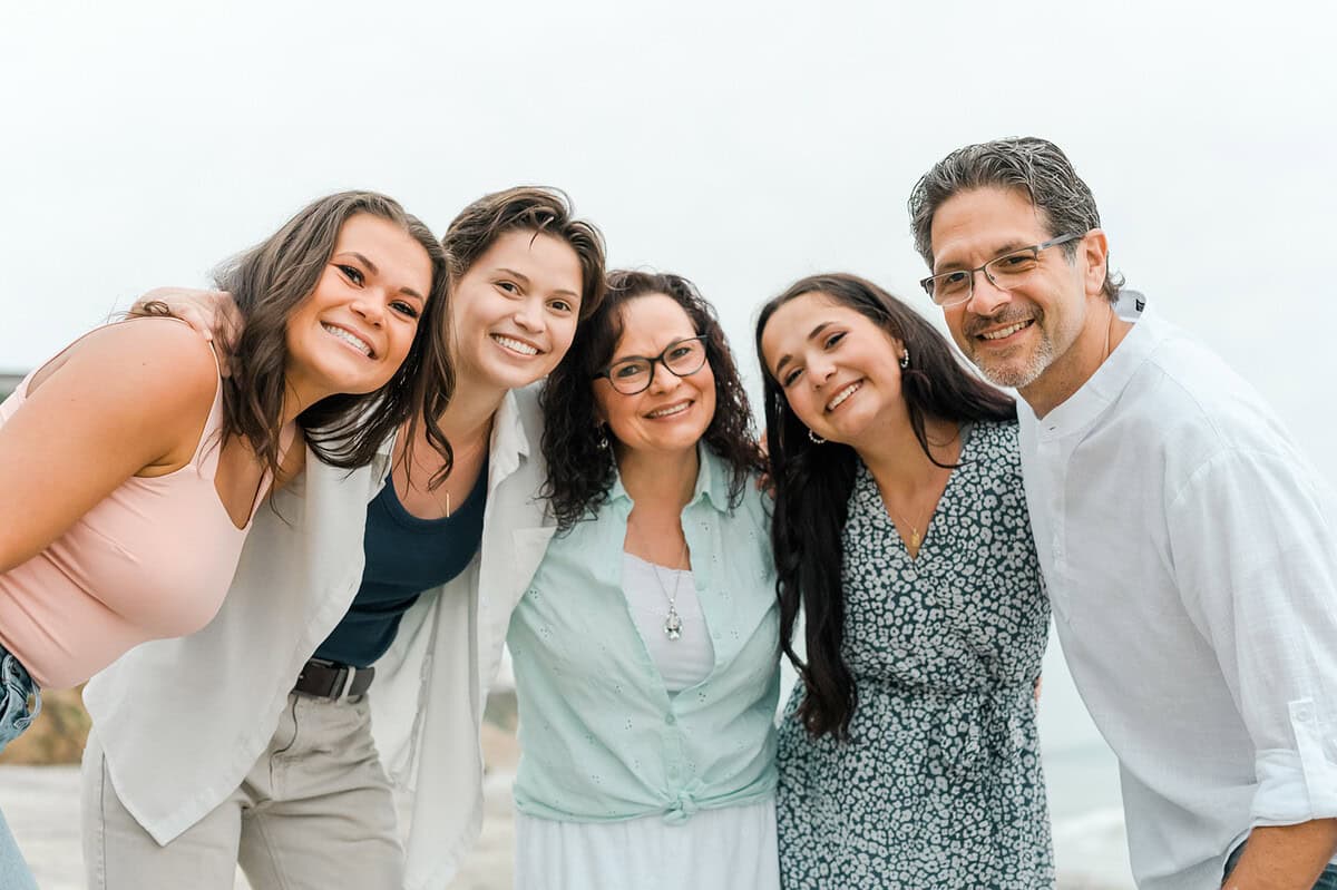 Jolayne and family smiling at the beach—travel bloggers enjoying a coastal vacation together