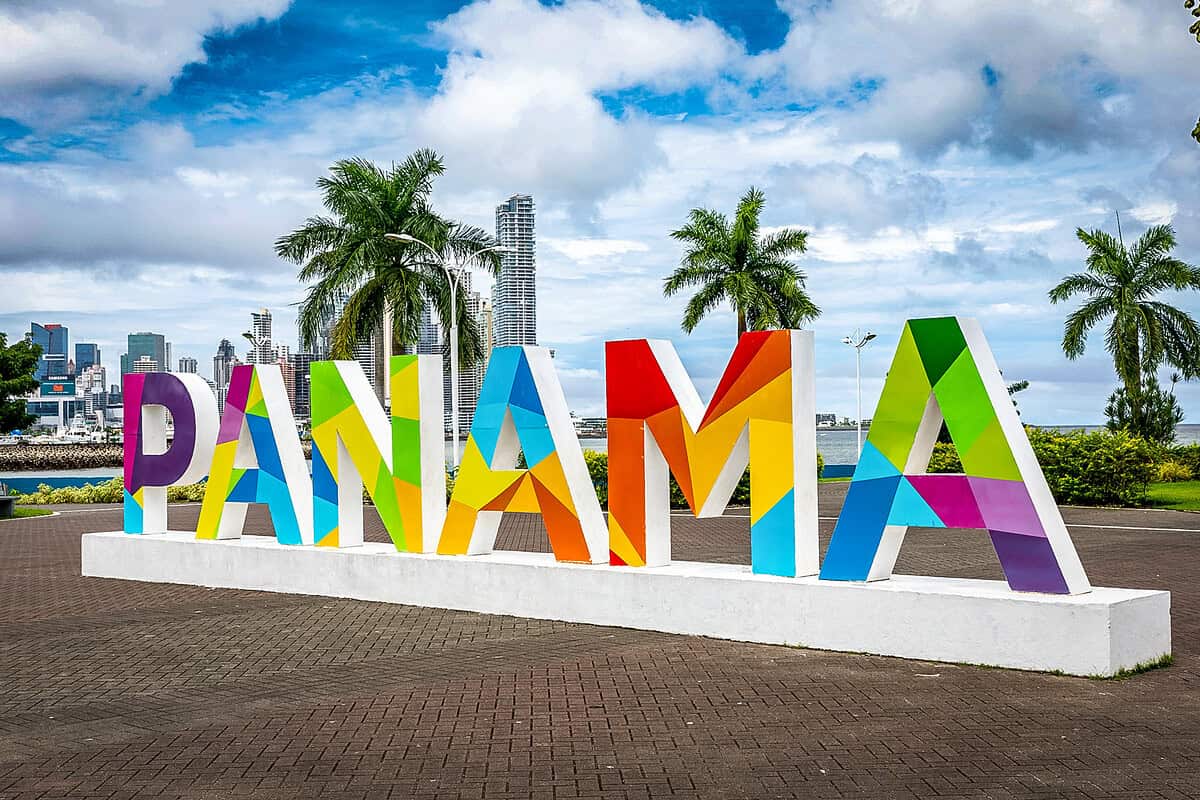 20210614 Panama by Curioso Travel Photagraphy 1003 Colorful 3D “Panama” sign with geometric patterns, palm trees, and the Panama City skyline in the background.