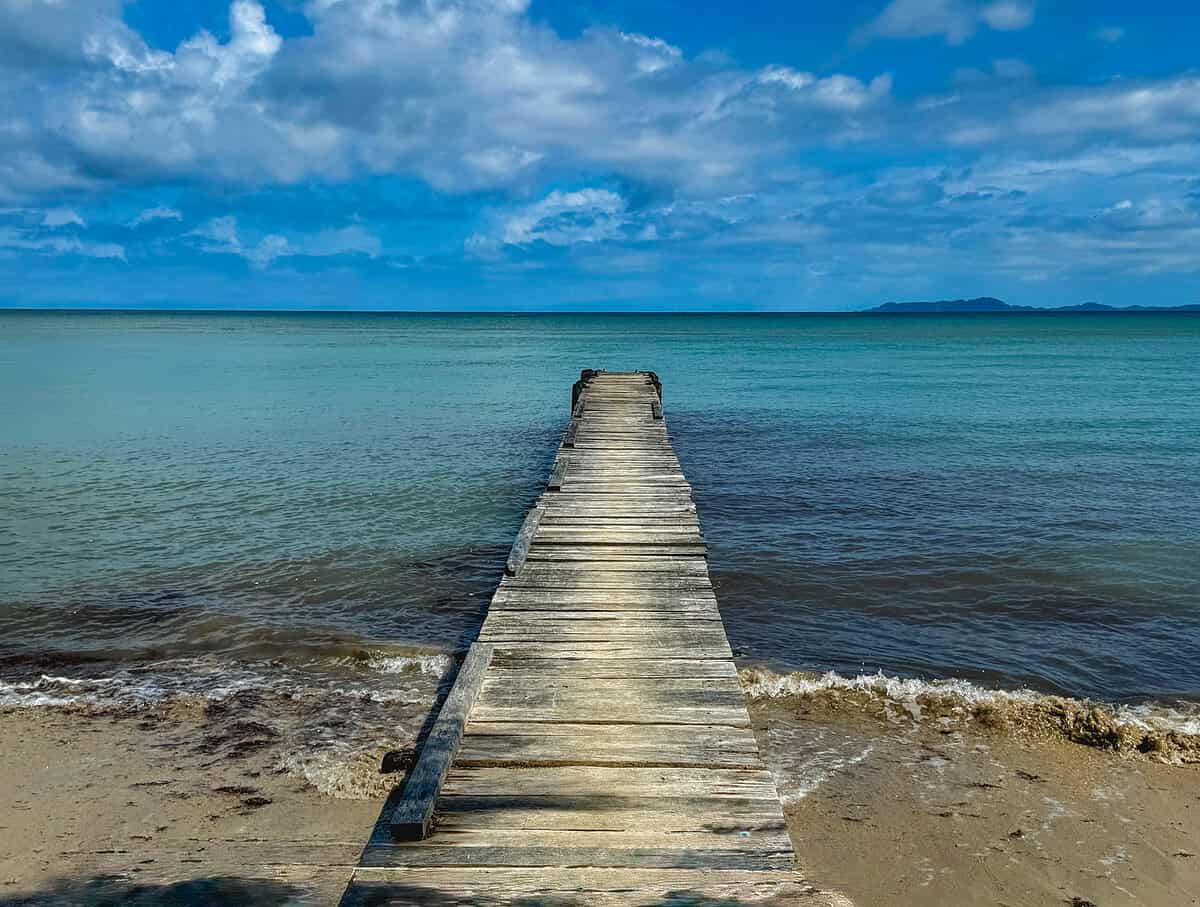 20260127 panama vs costa rica 2 1 Weathered wooden dock stretching into calm turquoise waters under a dramatic blue sky in Panama—perfect for a Panama vs Costa Rica comparison post.