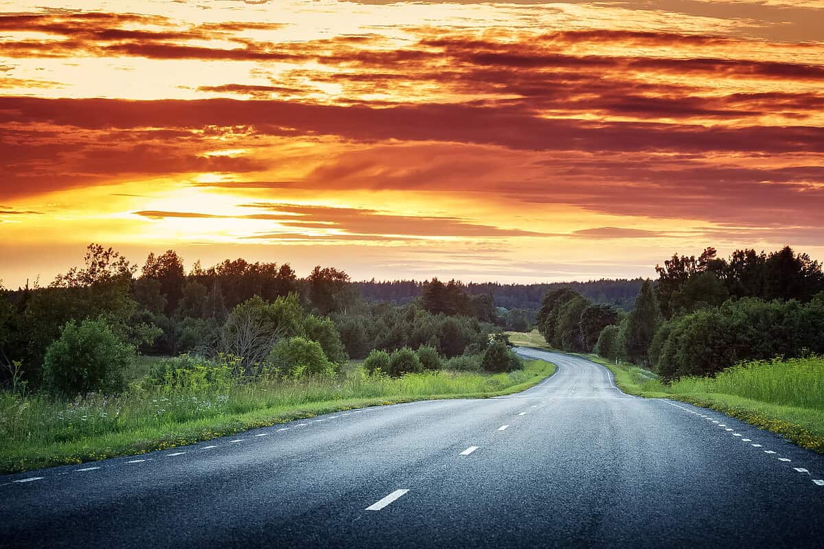 Open road stretching into the sunset horizon perfect for a Colorado road trip