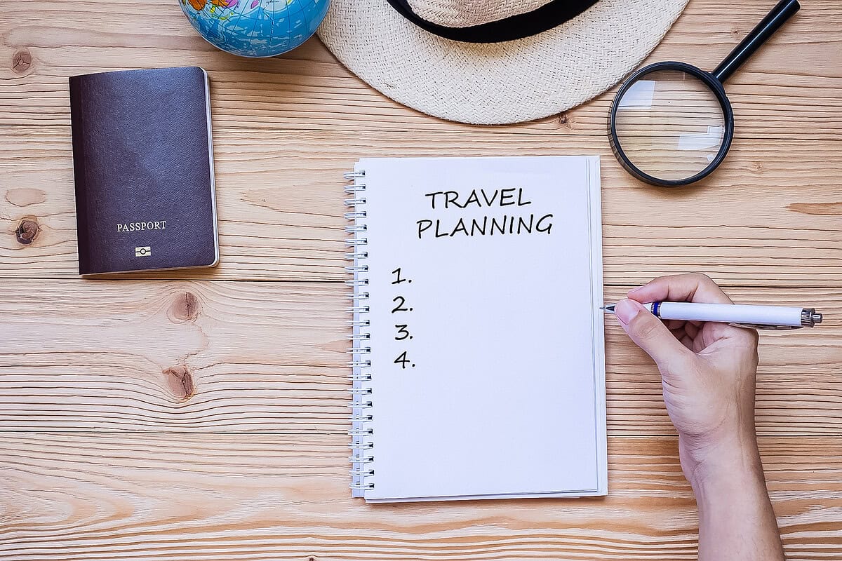20190505 how to plan an international trip 1003 How to plan an international trip checklist with notebook, passport, and magnifying glass on a wooden table