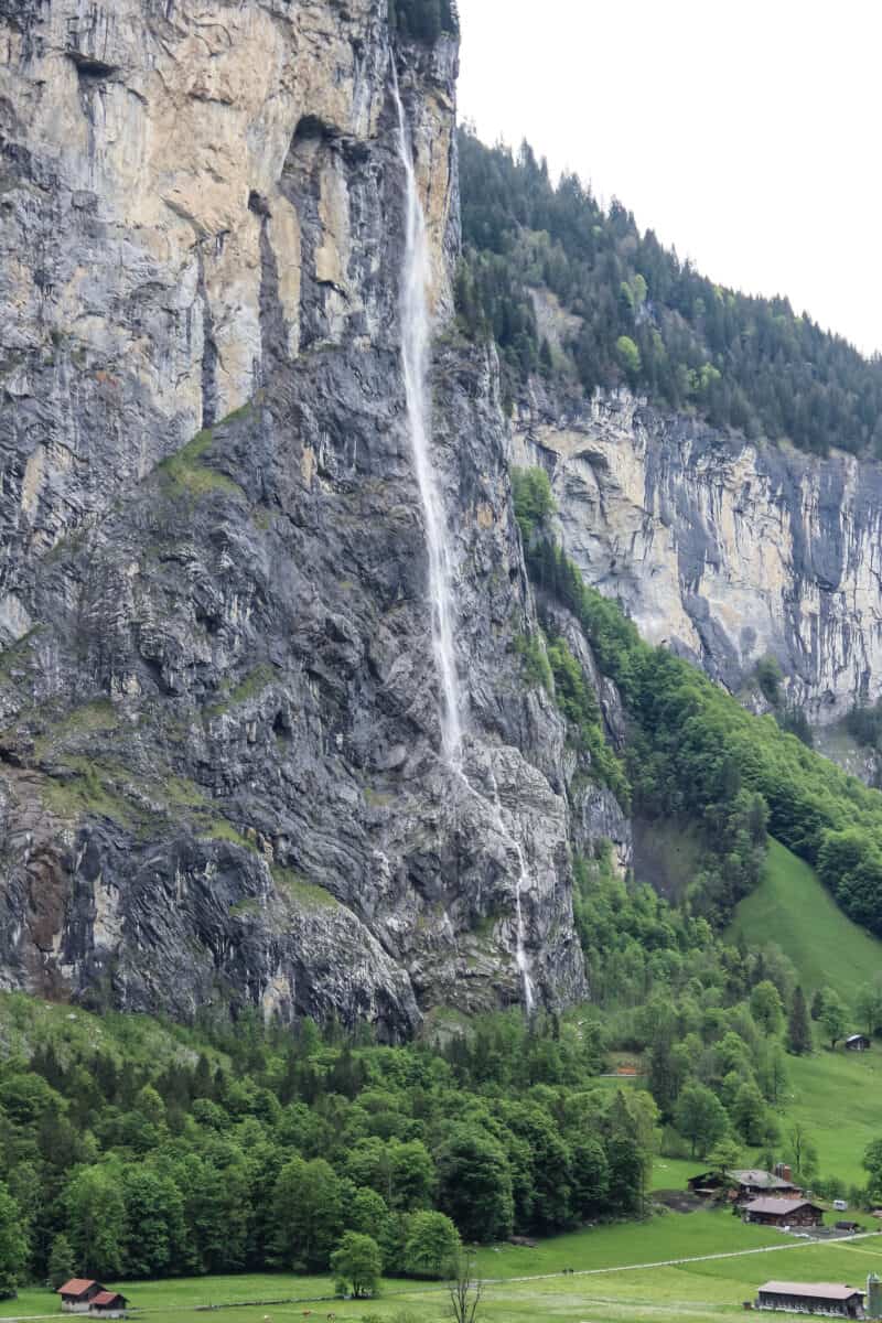 20190529 JK 0464 LRE Photo A tall waterfall cascades down a sheer cliff face into the green valley below in Lauterbrunnen, Switzerland.