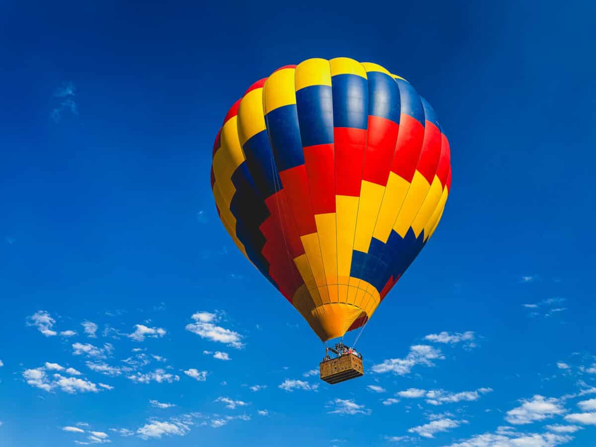 Colorful hot air balloon floating against a bright blue sky.