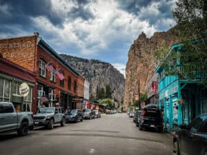Historic brick storefronts and towering rock cliffs along Main Street in Creede, Colorado.