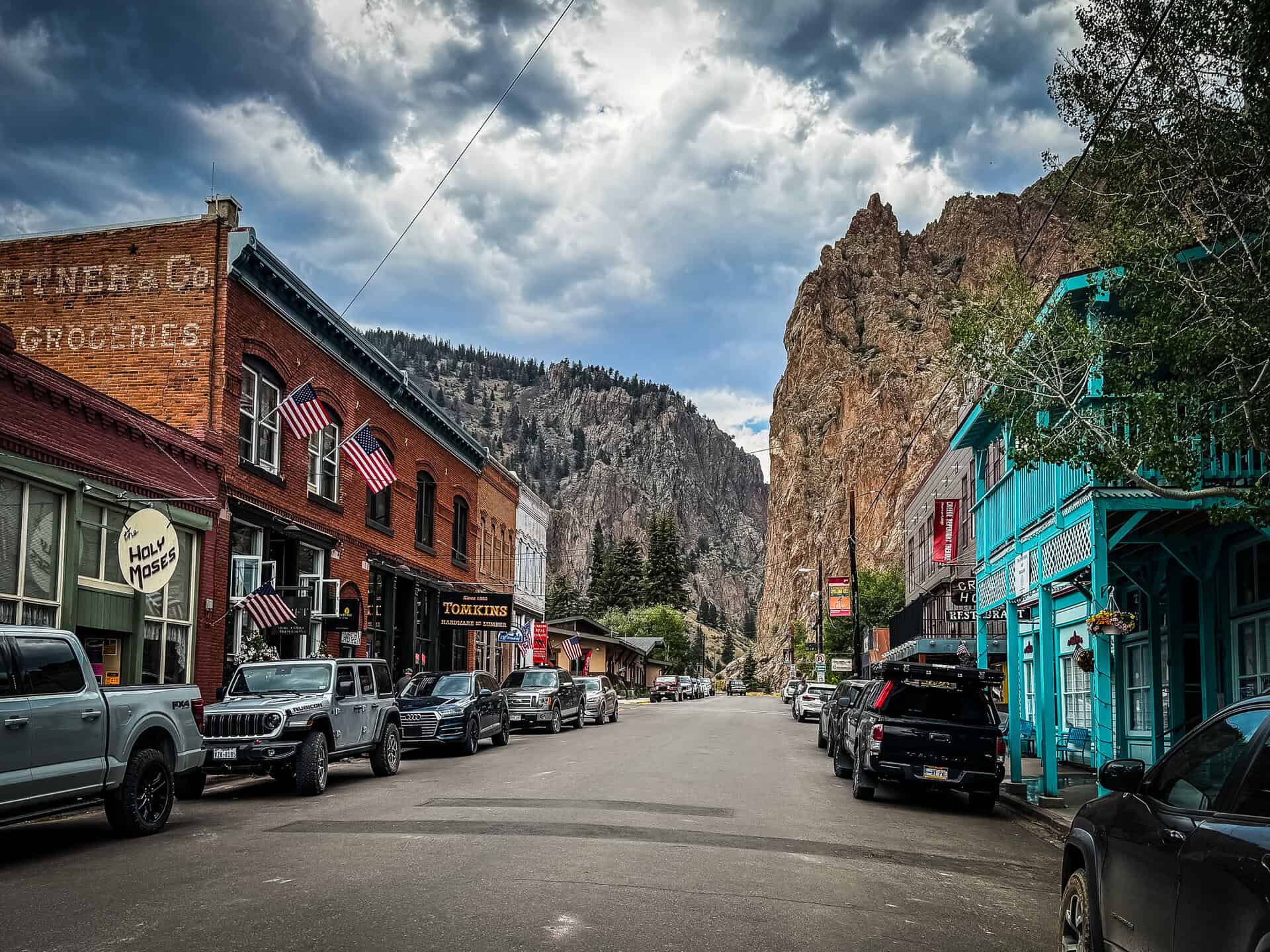 Historic brick storefronts and towering rock cliffs along Main Street in Creede, Colorado.