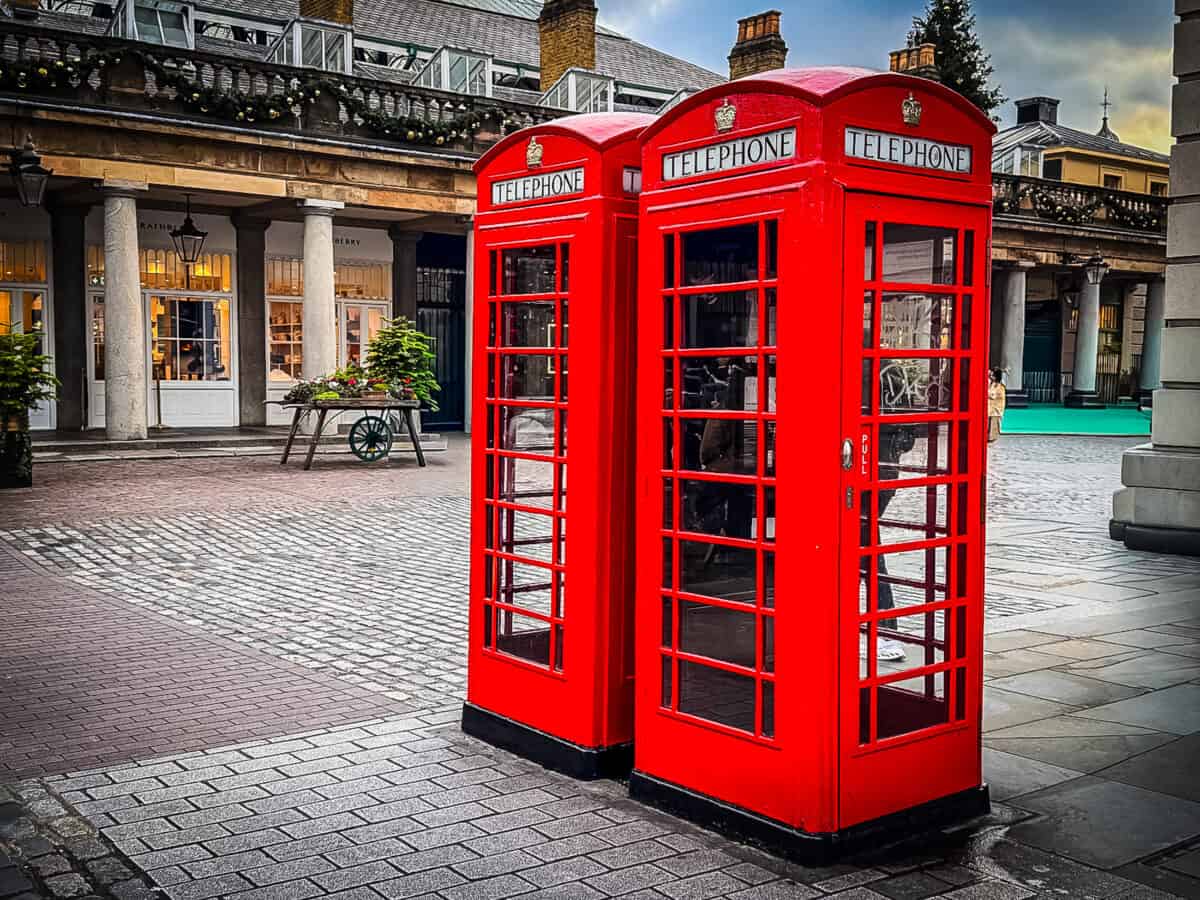 Two red telephone booths in Covent Garden, London are some of the iconic things to see when planning a trip to England.