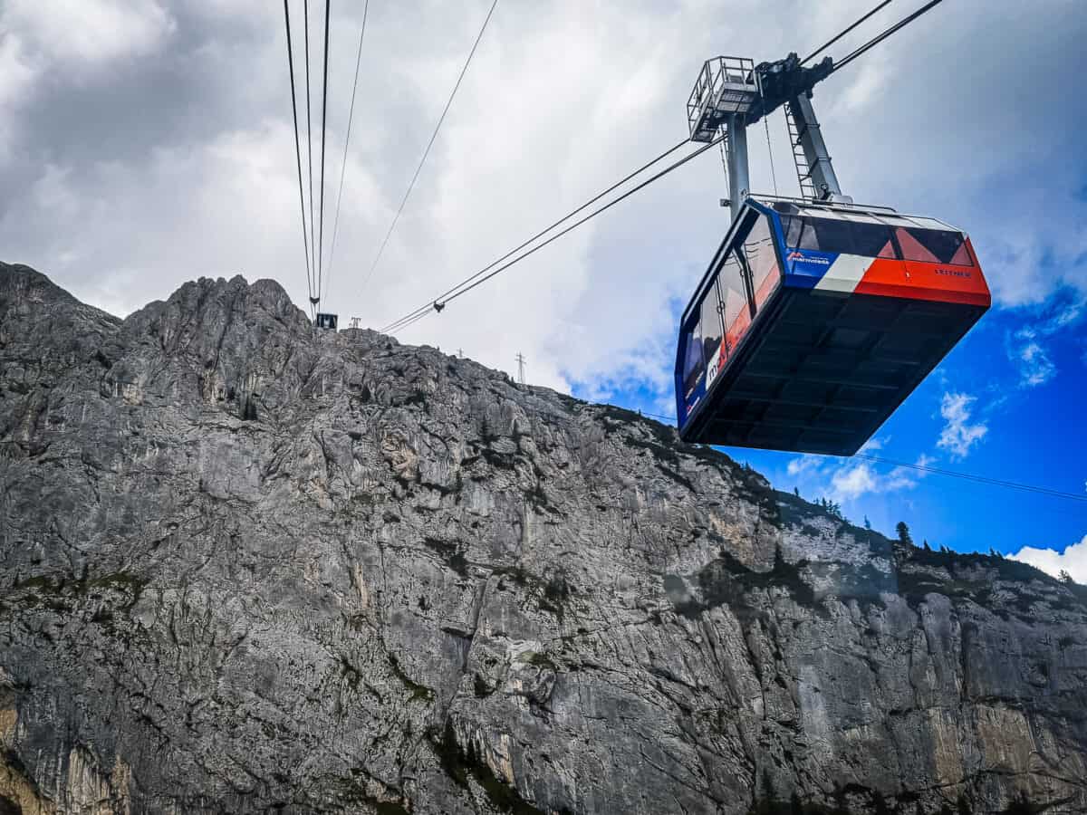 Marmolada cable car cabin passing a sheer rock face on the ride from Malga Ciapela toward Punta Rocca in the Dolomites.