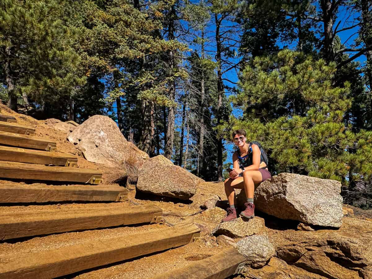 Misha resting on a rock beside the steep railroad-tie steps of the Manitou Incline.